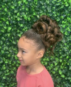 A young girl with a big messy bun on top of her head.