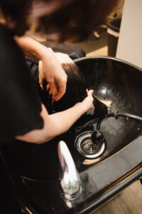 A person washing dishes in a sink.