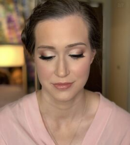 A woman with brown hair and a pink shirt