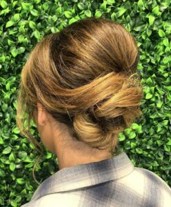 A woman with long hair is wearing a plaid shirt.