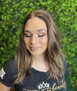 A woman with long hair and pink eye shadow.