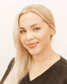 A woman with blonde hair and wearing a black shirt.