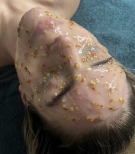 A woman with yellow and white sand all over her face.