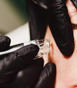 A person is getting their nails done with black gloves.