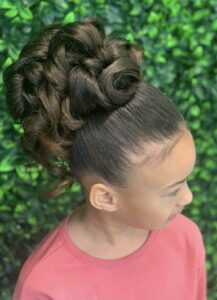 A young girl with long hair in a bun.