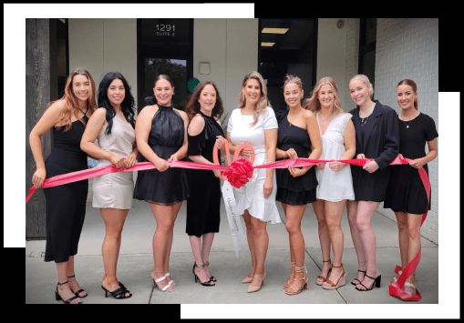 A group of women holding a ribbon in front of a building.